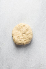 Overhead view of pasta dough being mixed on a white granite countertop, process of making homemade pasta dough
