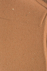 close up view of textured brown sand background, beautiful sand texture, overhead view of zen pattern drawn in brown sand, Top view of fine grain texture