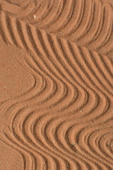 close up view of textured brown sand background, beautiful sand texture, overhead view of zen pattern drawn in brown sand, Top view of fine grain texture