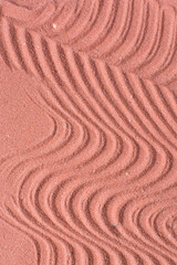 close up view of textured coral sand background, beautiful sand texture, overhead view of zen pattern drawn in coral sand, Top view of fine grain texture