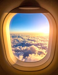 Sunny skies are viewed through an airplane window, with fluffy clouds beneath a brilliant blue gradient and setting sun
