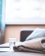 Cozy Interior with Folded Blanket and Glass of Water on Table