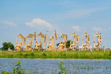Oil well pump jacks are working to pump crude oil out of the crude oil well.