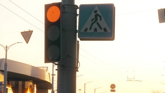 City Traffic Light and Pedestrian Crossing Sign at Sunset with Amber Signal
