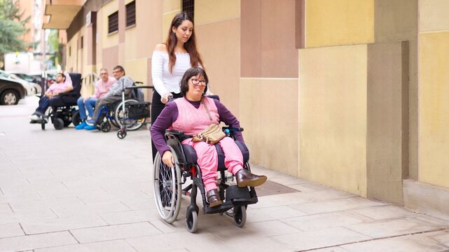 Caregiver assisting woman in wheelchair promoting inclusion and diversity