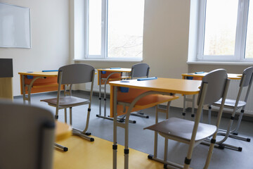 Desk with chairs in classroom at school
