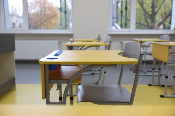 Stylish classroom with desks and chairs at school, closeup