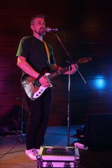 Fototapeta premium Handsome man playing electric guitar on stage