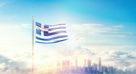 Greece flag wavering in beautiful clouds with building skyline. The flag with drone shot in beautiful sky. Greece national flag for independence day.