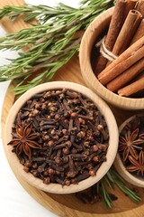 Different spices in bowls and fresh rosemary for mulled wine on table, top view