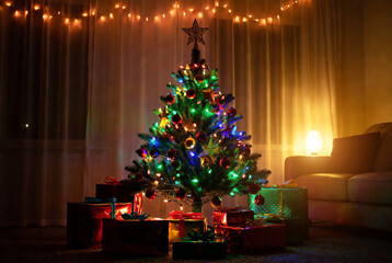 A festively decorated Christmas tree creates a warm and cozy atmosphere next to a blazing fireplace.