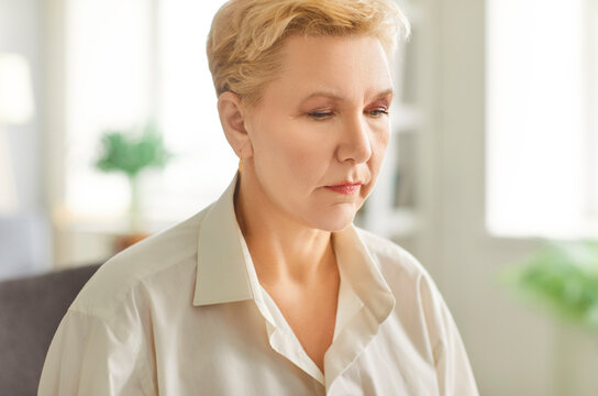 Pensive pleasant middle-aged aged woman face expression, alone looking sad thinking pondering, thoughtful senior female distracted lost in thoughts, feels lonely or bad at home in loneliness, stress