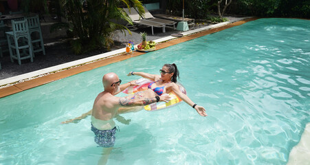 A man and a woman are having fun in the pool.