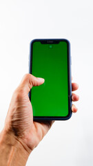 Hand holding smartphone with vibrant green screen for mockup use, isolated on clean white background.