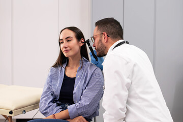 Obraz premium Male Doctor Examining Patients Ear