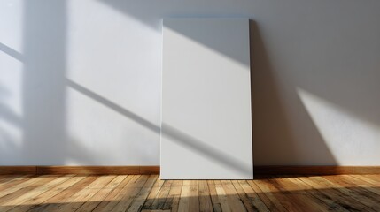 Vertical blank canvas leans against a white wall with dramatic sunlight and shadow patterns