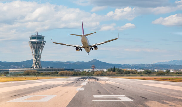 White Passenger plane fly up over take-off runway from airport - El Prat-Barcelona airport. This airport was inaugurated in 1963 - Barcelona, Spain