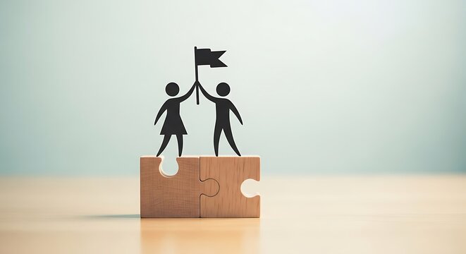Two silhouette figures holding a flag aloft while standing on connected puzzle pieces symbolizing teamwork and achievement