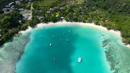 Beach bordered by green trees and clear blue sea. Port Launay Beach. Seychelles.
