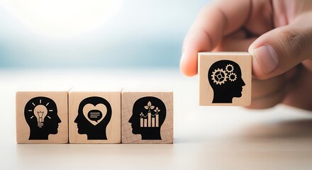 Hand placing wooden block with gear head icon next to blocks showing idea, emotion, and growth in business concept