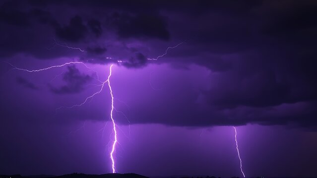 Dramatic purple lightning illuminating a stormy night sky, capturing raw natural energy.