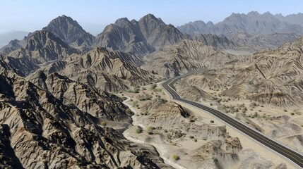 An aerial view of a road winding through a barren, mountainous desert landscape under a clear sky