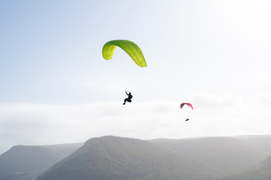 Paragliding against a brilliant sky and coastal mountain range