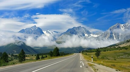 Asphalt road leads into misty mountains, framed by green hills and a bright blue sky