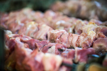 Close up detail from pork meat cooked on grill. Meat texture, generic photo of grill cooking. Rotating pork souvlaki on a grill with smoke and coal. Traditional Greek food.