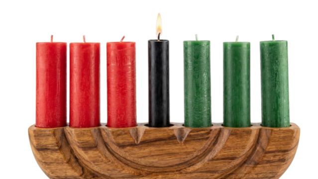 Seven vibrant red, black, and green candles stand in a wooden holder, with the central black candle burning bright, transparent png isolated. - Powered by Adobe