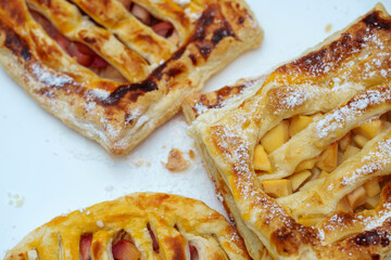 Apple tarts basking in the daylight, adorned with powdered sugar and a lattice crust, baked to golden perfection
