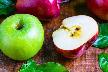Fresh green and red apples with spinach on a wooden surface