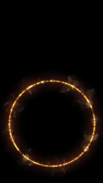 Golden glowing fire ring burning on a black background vertical video