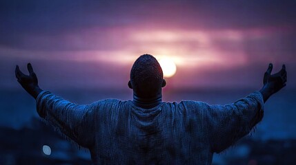 A man stands with his arms outstretched towards a vibrant sunset, his face turned upwards in a gesture of awe or prayer.