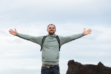 Happy man with arms outstretched enjoying nature in a scenic outdoor landscape