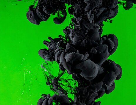 Black ink swirls gracefully through vivid green liquid