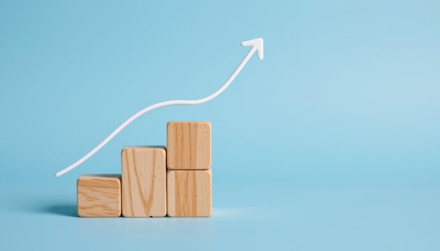 Wooden Blocks with Ascending Graph Arrow Representing Growth and Progress in Business on a Light Blue Background