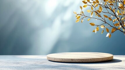 A minimalist scene featuring a stone podium against a soft blue background with dappled light and golden foliage.