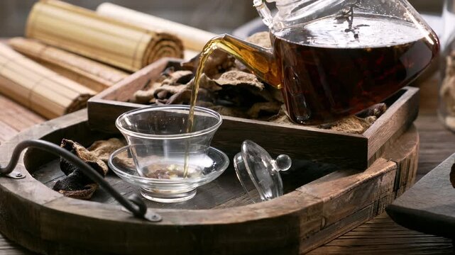 Traditional Chinese Tea Ceremony with Chenpi Dried Citrus Peel and Glass Teacup on Wooden Tray