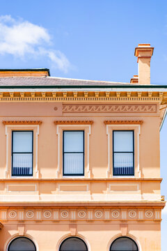 second story windows in creamy pink historic building in country town of Glen Innes