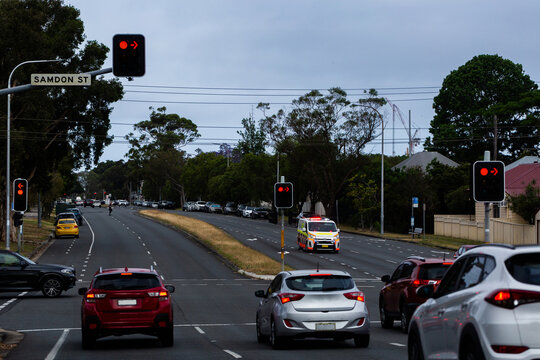Traffic on multilane city streets driving through Newcastle with ambulance passing through lights