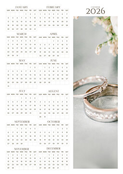 2026 yearly wall calendar with elegant wedding rings photo, soft romantic theme, minimal monthly grid layout, and printable planner design.