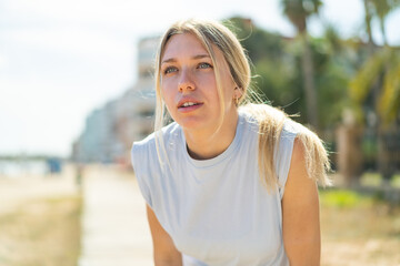 Young blonde woman at outdoors wearing sport wear
