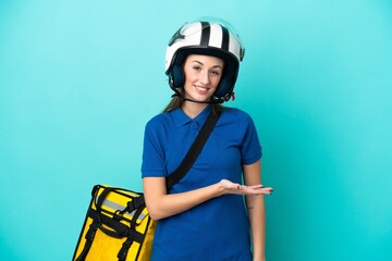 Young caucasian woman with thermal backpack isolated on white background presenting an idea while looking smiling towards