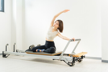 ピラティス女子 日本人女性がリフォーマーでポーズ