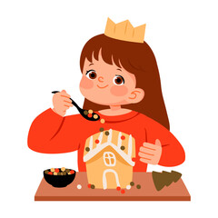 Girl decorating gingerbread house. Cute young girl in festive outfit enjoying Christmas fun by adding colorful candy to a gingerbread house.