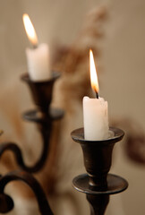 Two candles are lit in a candlestick holder