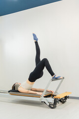 ピラティス女子 日本人女性がリフォーマーでポーズ