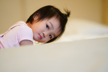 Smiling Baby Lying on Bed in Yellow Onesie