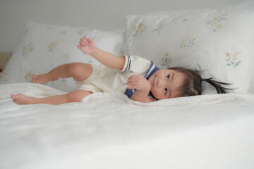Cute baby lying on bed in soft natural light